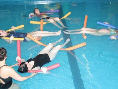 Een zwemlerares met 4 zwangere vrouwen die drijven in het water